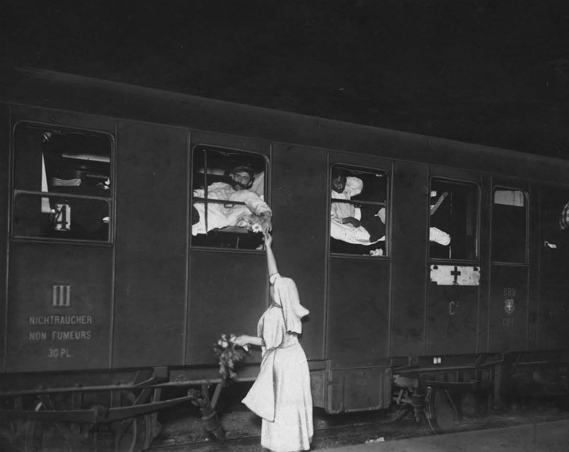 First World War. Geneva. Repatriation of seriously wounded soldiers from France, who were detained in Germany. Medical personnel of the Swiss Red Cross is attending to them outside the train. ICRC audiovisual archives / R. Gilli / V-P-HIST-00323-2